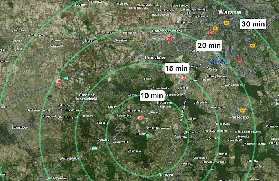 Mapa satelitarna okolic Warszawy z zaznaczonymi strefami dojazdu 10, 15, 20 i 30 minut od wybranej lokalizacji.